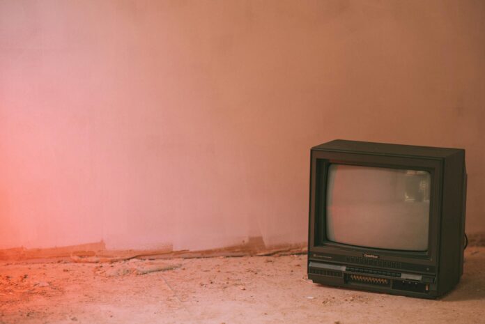 aged television set reflecting old house near wall